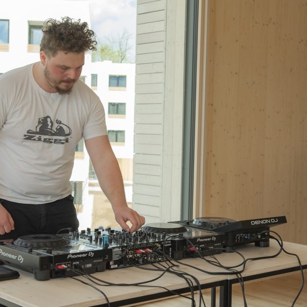 Fotografija iz otvoritve – 18 DJ delavnica, moški ki upravlja mešalko