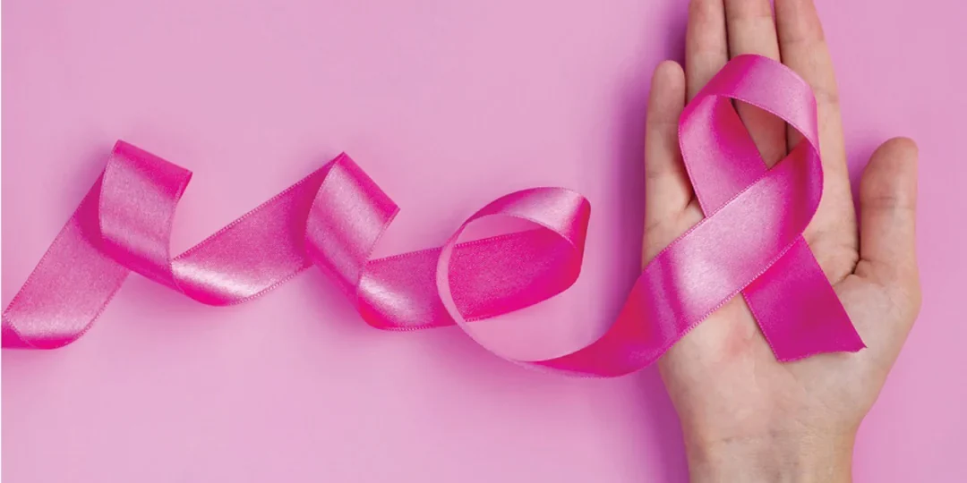 Roka ki drži roza mašno. Naslovna slika dogodka rožnati oktober.